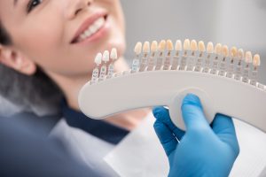 A woman having her shade matched at the dentist 