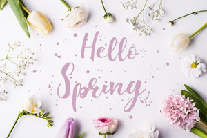 Flowers laying around the words “Hello Spring”