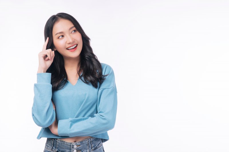 a woman smiling and thinking about cosmetic dentistry